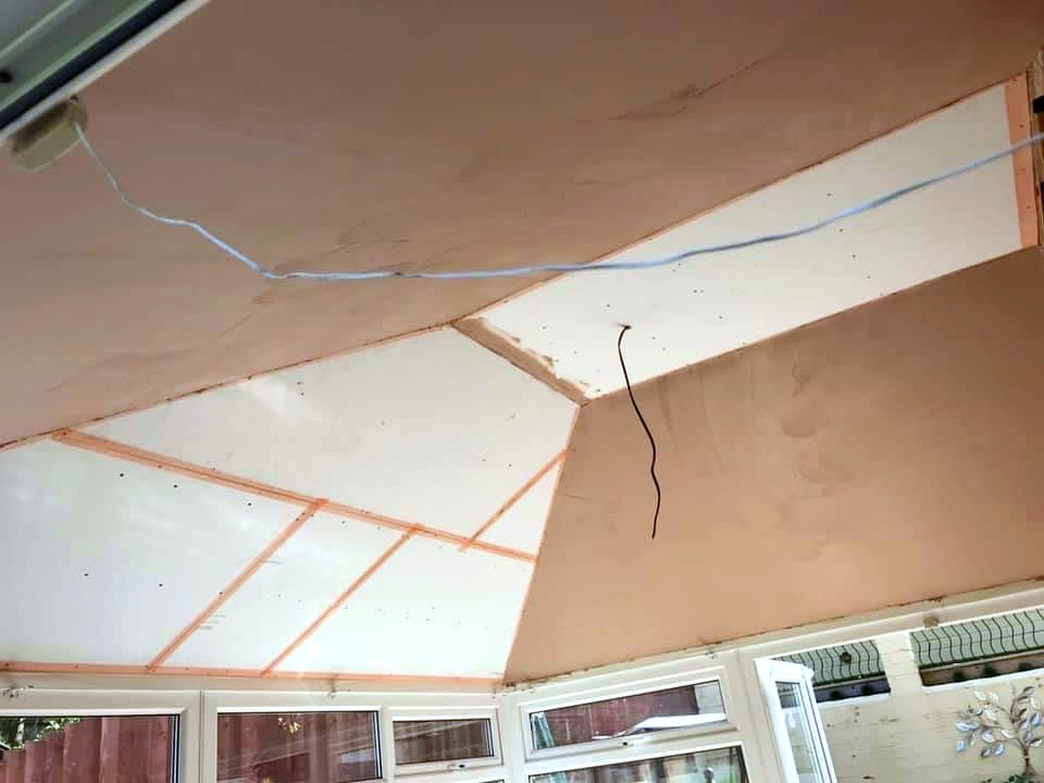 Fresh plaster skim applied to conservatory ceiling with light wire hanging